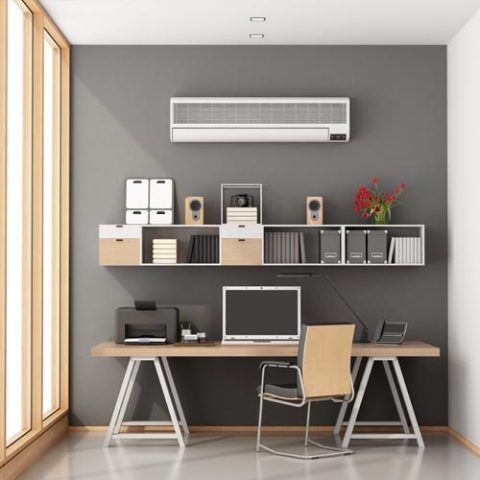 Wall-mounted split air conditioning unit installed above a home office desk